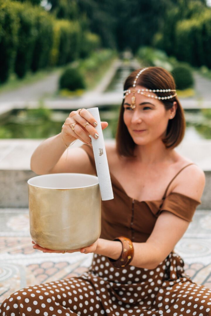 a beautiful woman holding a crystal singing bowl